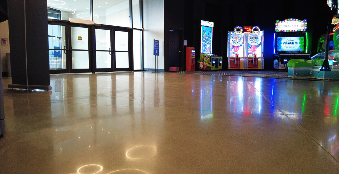 Cineplex interior entrance, polished concrete floors and arcade games in background.